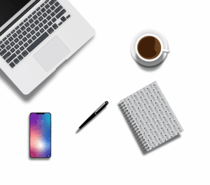 Arbeitsplatz in weiss mit Notebook, Handy, Notizblock und Kaffeetasse